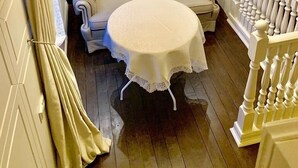A cozy room with a tufted sofa, a round table, and a chandelier. - Apartment Fodorova 1 (Lviv)