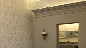 A bedroom with a patterned wall, a bed with a herringbone mattress, and a wall-mounted light fixture. - Apartment Fodorova 1 (Lviv)