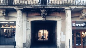 An entrance with a cobblestone path leading to a gated area. - Apartment Svobody 10 (Lviv)