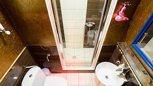 Ein modernes Badezimmer mit einer gläsernen Duschkabine, zwei Waschbecken und einer Toilette.