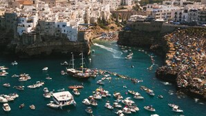 A coastal town with numerous boats and a crowded beach area. - B&B Il Nido delle Rondini (Conversano)