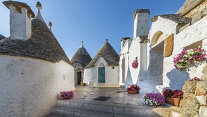 A narrow street with white buildings and conical roofs. - B&B Il Nido delle Rondini (Conversano)