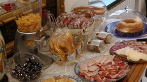 A buffet table with various food items including bread, pastries, meats, and cheeses. - Alle Vecchie Mura (Pistoia)