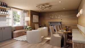 A modern living room with a fireplace, wicker furniture, and a wine rack. -  Shore Haven Inn (Falmouth)