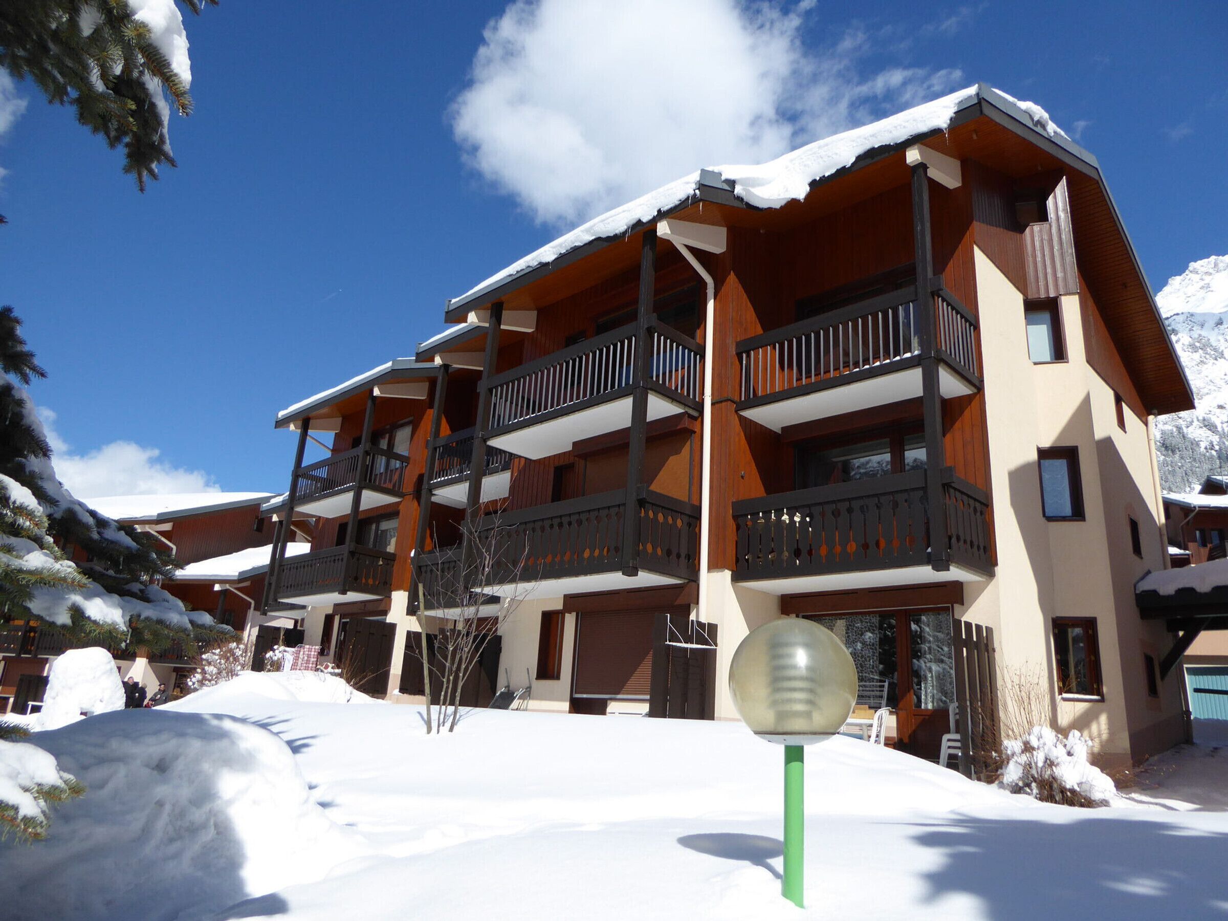 Ein mehrstöckiges Hotel mit Balkonen vor einer verschneiten Landschaft.
