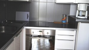 Een koffiezetapparaat/waterkoker, een koelkast, een magnetron, een oven