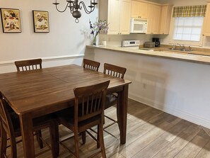 Enjoy cooking in this well-appointed kitchen with a central island, microwave, and toaster, surrounded by a dining table and chairs.
