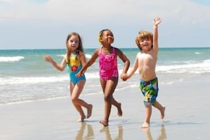 Children can play freely along this sandy beach, perfect for a family vacation.