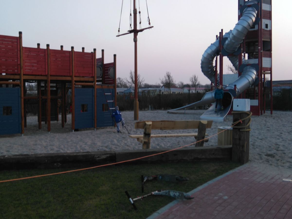 Une aire de jeux avec un toboggan et des structures d’escalade.