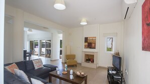 A modern living room with a sofa set, a coffee table, a television, and a fireplace. - Villa Molly, Lovely 3BDR Protaras Villa with Pool, Close to Fig Tree Bay Beach (Protaras)