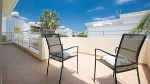 A rooftop terrace with two black metal chairs and a palm tree. - Villa Molly, Lovely 3BDR Protaras Villa with Pool, Close to Fig Tree Bay Beach (Protaras)