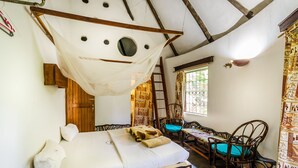 Une pièce avec un lit, une échelle en bois, une fenêtre avec des rideaux et un panier en osier.
