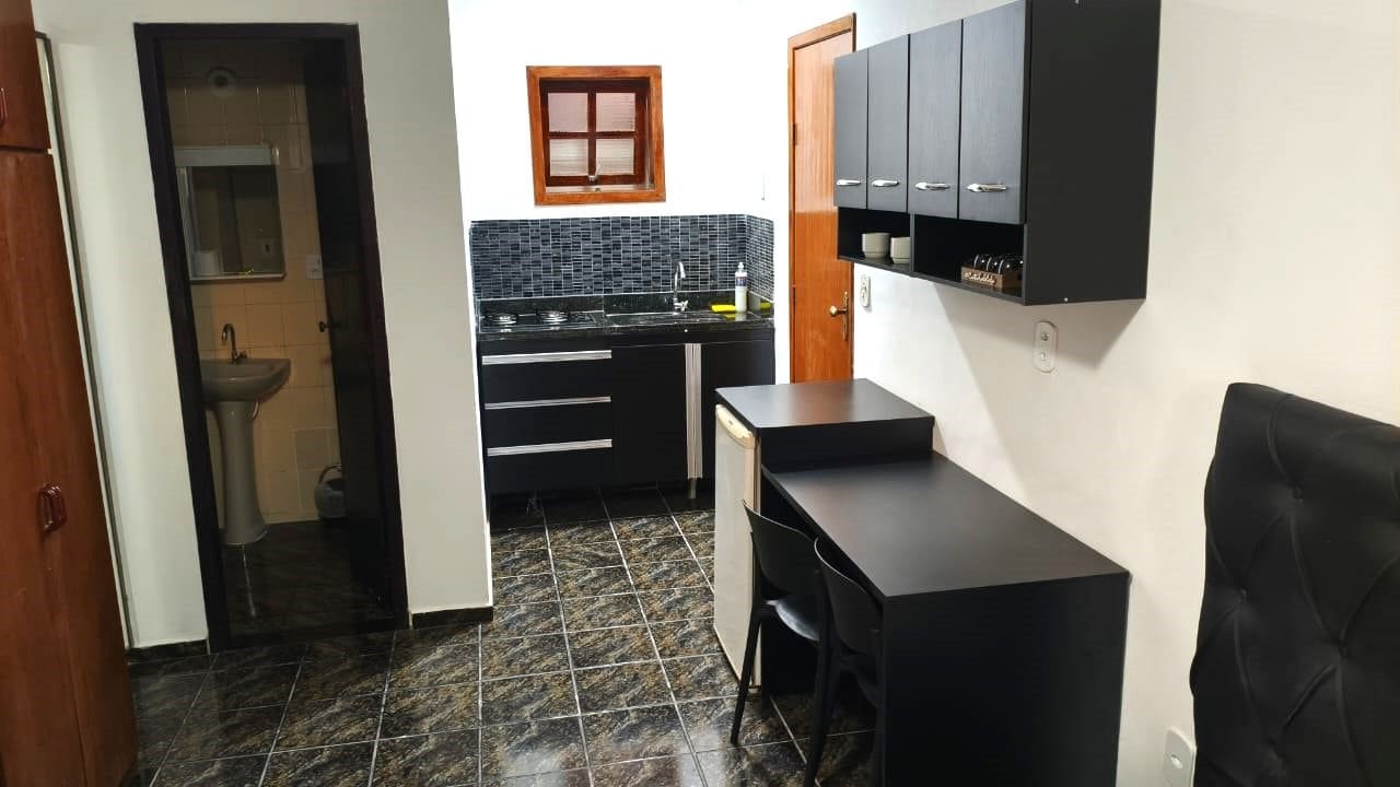 A compact kitchen with a sink, countertop, and cabinets.