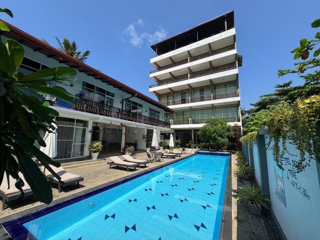 Una piscina al aire libre, sillones reclinables de piscina