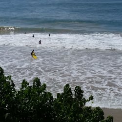 On the beach, surfing