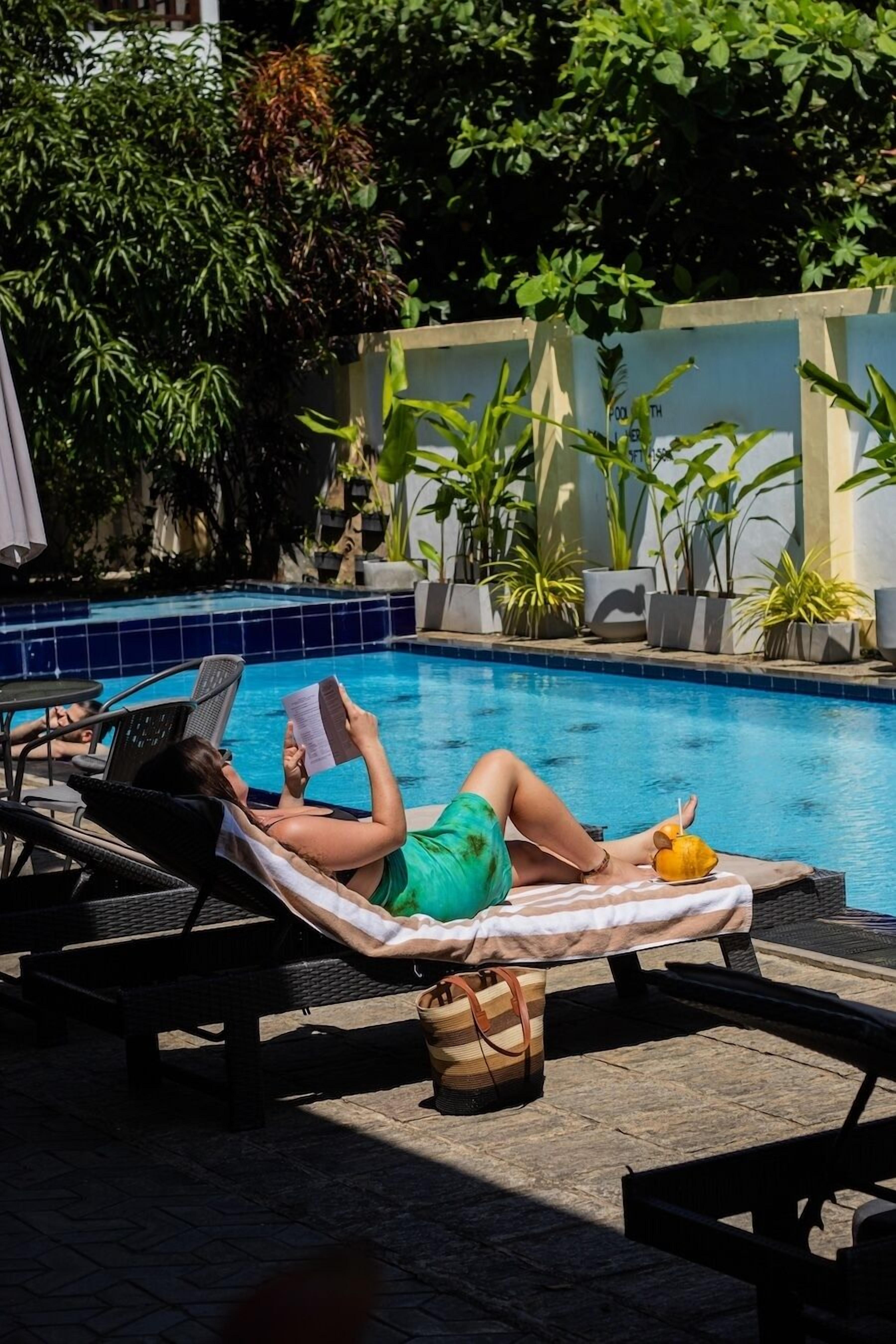 Una piscina al aire libre, sillones reclinables de piscina