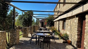 Eine Außenpatio-Terrasse mit Steinmauern, Tischen und Stühlen.
