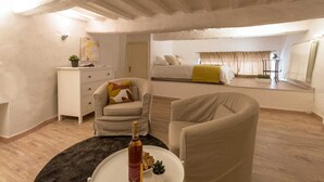 A cozy room with a bed, a sofa, a small table with a bottle, and a dresser. - Il Cuore di Chiusi - House in the historic center (Unknown)