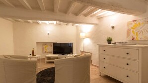 A cozy living room with a television, sofa, and a white dresser. - Il Cuore di Chiusi - House in the historic center (Unknown)