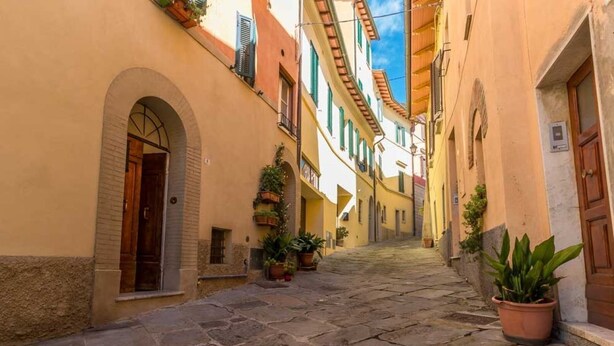 A narrow cobblestone street flanked by buildings with arched doorways and windows. - Il Cuore di Chiusi - House in the historic center (Unknown)
