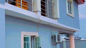 A two-story building with a balcony, a red roof, and a satellite dish. - Volantis Gold (Lagos)