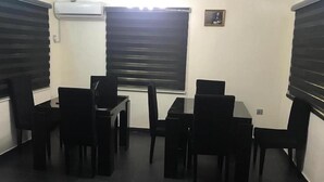 A conference room with a table and chairs, an air conditioning unit, and a window with blinds. - Volantis Gold (Lagos)