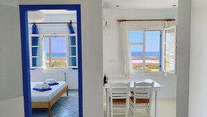 Une chambre à coucher avec un lit, une fenêtre avec des rideaux et une vue sur la mer.
