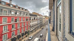 A row of multi-story buildings with balconies, a street with cars, and a clear sky. - Tracey & Neill's Place by Portugal Portfolio (Misericórdia/ Lisbon)