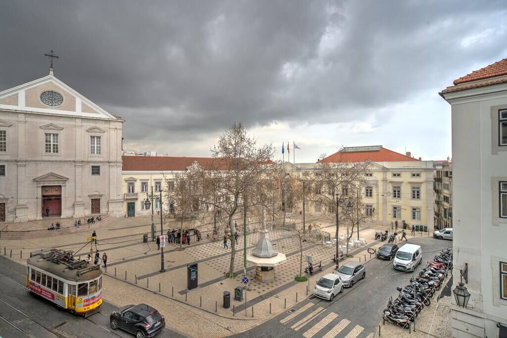 Ein Stadtplatz mit Straßenbahn, Gebäuden und einem Brunnen.