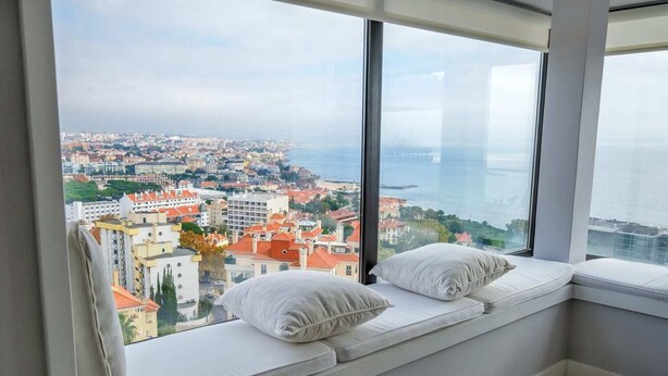Habitación en un rascacielos con un ventanal grande que ofrece vistas a la ciudad.