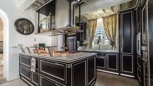 A modern kitchen with black cabinetry, a central island, and a large clock on the wall. - Luxury Villa located between Florence and Siena. A/C, swimming pool and SPA! (Tavarnelle val di Pesa)