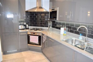 Une cuisine moderne équipée d’une cuisinière, d’un four et d’un four à micro-ondes en acier inoxydable.