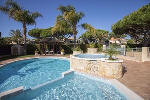 A swimming pool with a hot tub, surrounded by palm trees and a gazebo. - Villa Hera | 6 Bedrooms | Outdoor Spa & More | ViIamoura (Vilamoura)