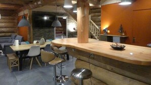 A rustic wooden interior with a dining area, bar, and seating. - ----The evening Star---- (Saint-Martin-de-la-Porte)
