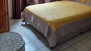 A bedroom with a large bed, a small round table, and a window with curtains. - The luminous dodo ★★★ (La Saline-Les-Bains)