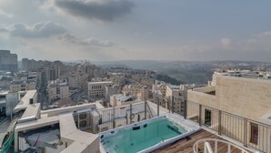 A rooftop pool with a cityscape view, surrounded by buildings and a clear sky. - Jerusalem Penthouse (Jerusalem)