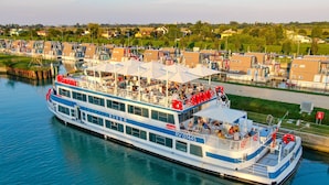 Un barco de crucero fluvial con varias cubiertas y zonas de estar al aire libre.