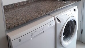 A compact kitchen with a microwave, toaster, and washing machine. - DUPLEX LA PUNTILLA (Chacras de Coria)