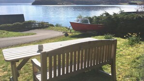 A wooden bench overlooking a lake with a boat docked nearby.