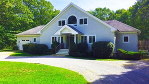 A two-story house with a front porch, a driveway, and a well-maintained lawn. - 6 Bedroom, 5 Bath Home with Pool, Sag Harbor - Near Bridgehampton (Sag Harbor)