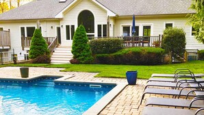 A swimming pool with lounge chairs and a house in the background. - 6 Bedroom, 5 Bath Home with Pool, Sag Harbor - Near Bridgehampton (Sag Harbor)