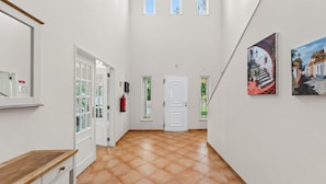 A hallway with a tiled floor, white walls, and a door at the end. - Villa Jasmim | 4 Bedrooms | Sun Kissed | Almancil (Almancil)
