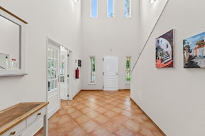 A hallway with a tiled floor, white walls, and a door at the end. - Villa Jasmim | 4 Bedrooms | Sun Kissed | Almancil (Almancil)