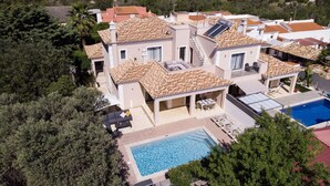 A large villa with multiple levels, a swimming pool, and a covered outdoor seating area. - Casa no Sol | 3 Bedrooms | Modern | Almancil (Almancil)