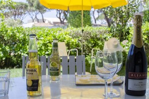 Een tafel met een fles Corona Extra, een fles Somersby appelcider, een fles Tinto Bruto en twee glazen.