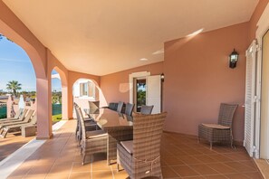 A covered outdoor seating area with wicker furniture and a view of the pool. - Villa Anita | 5 Bedrooms | Private | Vilamoura (Vilamoura)