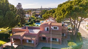 A multi-story building with a swimming pool, surrounded by greenery and trees. - Villa Anita | 5 Bedrooms | Private | Vilamoura (Vilamoura)