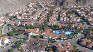 A residential area with houses, a swimming pool, and a mountain backdrop. - Mountain Views! Mountains, Palms & Blue Skies, Pet Friendly! - Upstairs w/Garage (L56-2) (La Quinta)