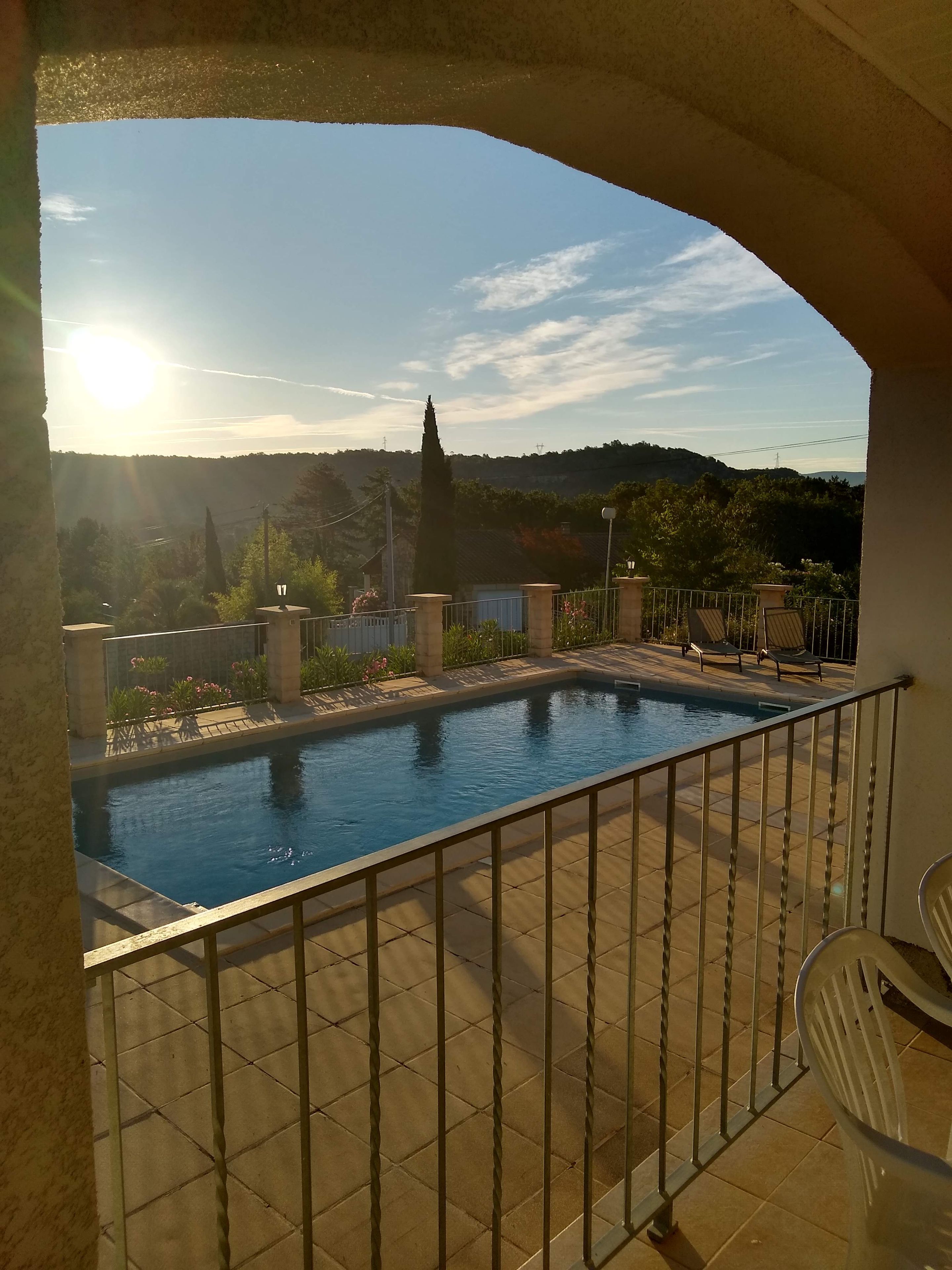 A swimming pool with a view of a hill and a clear sky.