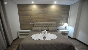 A modern bedroom with a large bed, a nightstand, and a lamp. - Hotel Barcelona (Ponta Pora)